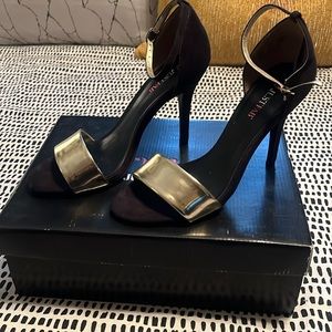 Just Fab Black and Gold Carilo heel with strap and gold buckle.